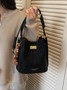 Sac seau vintage en cuir noir avec ferrures dorées et breloque en perles colorées