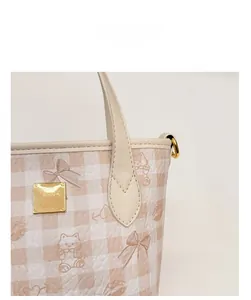 Detail of checkered bucket bag with cat and bow prints and gold square metal hardware