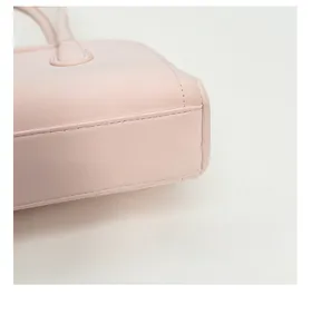 Detail shot of pink handbag showing reinforced corners and precision stitching on PU leather