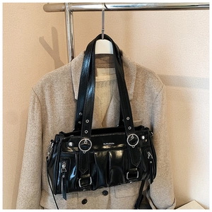 Détail du sac cabas noir brillant avec plis, finitions argentées et bandoulière à œillets
