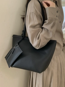 Minimalist black tote bag with white contrast stitching and a small matching pouch