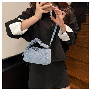 Mirror selfie showing a light blue denim handbag with a scrunchie handle and crossbody strap