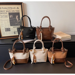 Various vintage bucket bags in black, brown, and cream with beaded charms and leather texture
