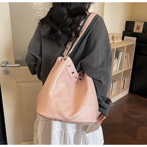 Detail view of pink tote bag with metal eyelets and premium leather texture on shoulder strap