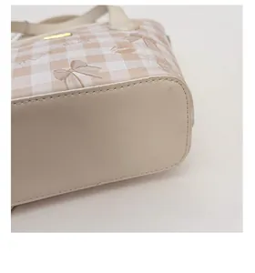 Detailed view of the thickened bottom support and plaid pattern on this handbag
