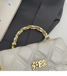 Détail du sac à main en cuir matelassé avec fermoir doré et bandoulière en chaîne