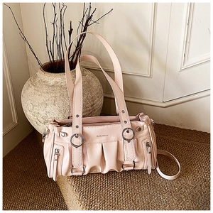 Détails du sac cabas plissé rose montrant les anneaux métalliques et le cuir verni