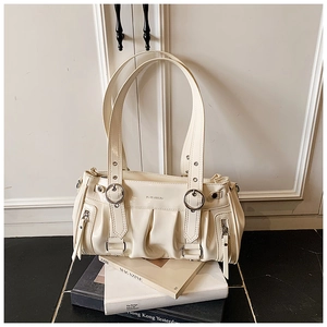 Détail du sac cabas plissé en cuir verni crème avec anneaux métalliques et poches zippées