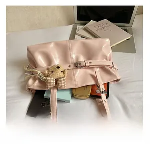 Internal view of pink glossy tote bag showing spacious capacity with a cute bear charm