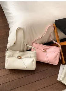 Detailed view of cream and pink tote bags with textured leather and metal buckles