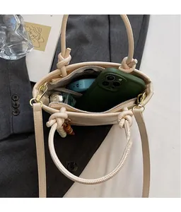 Interior view of beige patchwork tote bag with phone and perfume for storage capacity