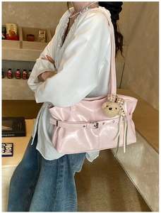 Detailed view of pink faux leather tote bag featuring silver buckle and cute teddy charm
