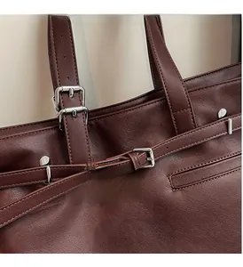 Détail du sac cabas en cuir bordeaux avec ferrures argentées et ornements de rivets