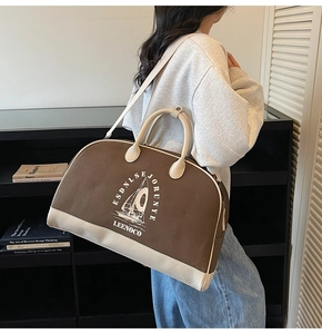 Dettaglio della borsa da viaggio in tela e pelle con zip e tracolla regolabile rimovibile