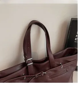 Détail du sac cabas en cuir bordeaux avec large anse et boucle en métal argenté