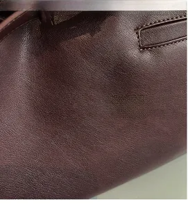 Gros plan sur la texture du cuir grainé marron foncé et les détails des coutures