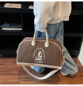 Dettaglio di borsa da viaggio in tela marrone con motivo a vela e tracolla regolabile