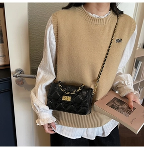 Détail du sac matelassé noir avec fermoir doré et texture en cuir brillant