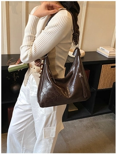 Détail du sac hobo vintage marron foncé avec sangle nouée et texture cuir ciré lisse