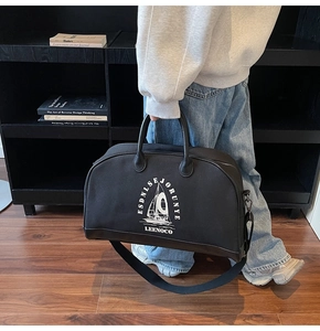 Vista laterale della grande borsa da viaggio in tela nera con stampa a vela e manici
