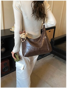 Détail du grand sac cabas marron foncé avec texture cuir et charm peluche chiot