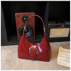 Détail du sac à bandoulière bordeaux avec une boucle métallique argentée élégante
