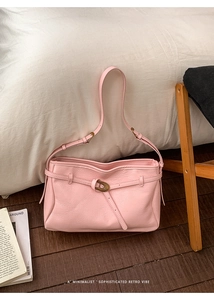 Detail shot of a pink leather tote bag featuring vintage bronze buckle and textured finish