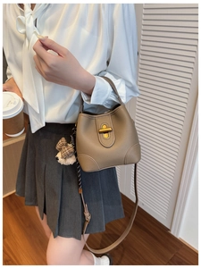 Detail der kaffeebraunen Beuteltasche mit Litschi-Leder und Hundeanhänger