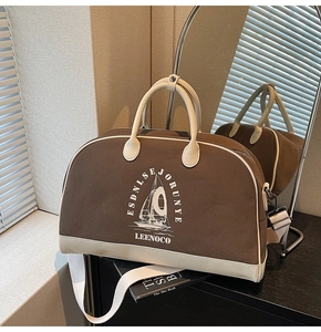 Dettaglio di una borsa da viaggio vintage in tela con finiture in pelle e tracolla a righe