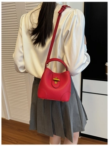 Nahaufnahme der roten Beuteltasche aus Leder mit Lychee-Muster und Goldverschluss