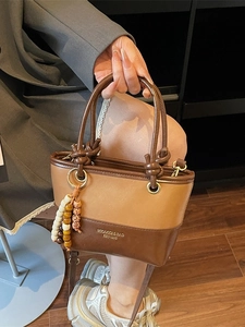 Retro two-tone leather crossbody bucket bag with decorative beads and metal rings