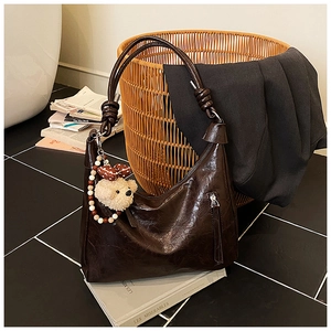 Détail du sac cabas vintage en cuir froissé marron avec bandoulière nouée et peluche