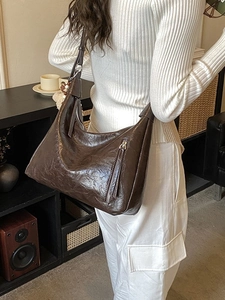 Grand sac fourre-tout hobo marron foncé rétro avec texture vintage porté par un mannequin