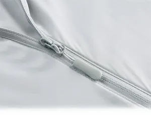 Close-up of high-quality non-slip zipper and fine texture on light gray sun protection jacket