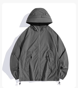 Détail de la veste de protection solaire gris foncé avec capuche et poches zippées