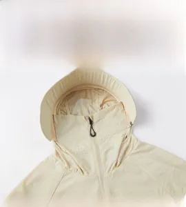 Détail de la veste anti-UV beige avec masque respirant et capuche à visière rigide