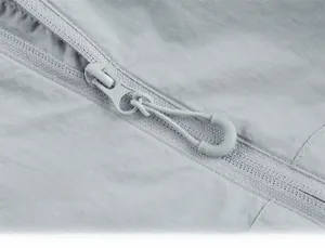 Detailed close-up of light gray waterproof zipper with woven rope pull on sun shirt
