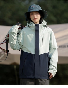 Detail of 3-in-1 waterproof hooded jacket featuring mint green and navy blue paneling