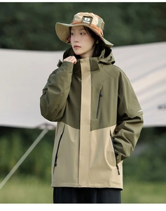 Detail of color-block windproof outdoor jacket in olive green with matching bucket hat