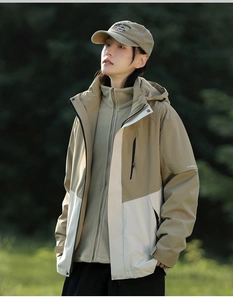 Detail of color-block outdoor jacket showing khaki and beige fabric with soft fleece lining