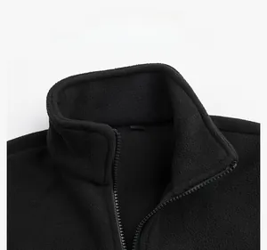 Close-up of black fleece jacket collar with zipper and gold size L label detail
