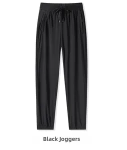 Detail of black ice silk pants showing elastic drawstring waist and zippered pockets
