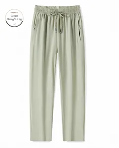 Détail du pantalon vert en soie glacée avec taille élastique et poches zippées pratiques