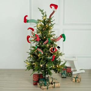 Detail of plush elf leg ornaments with stripes and dots on a lit Christmas tree