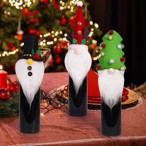 Three Christmas gnome wine bottle covers with white beards on a festive dinner table