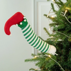 Close-up of elf leg tree decoration with red boots and green white striped knit fabric