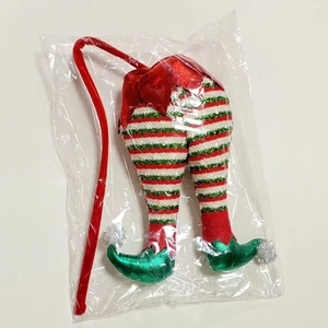 Close-up of striped Christmas elf legs decoration with green shoes and pom-pom details