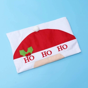 Detail of red and white Christmas chair cover with HO HO HO text and pom-pom decor