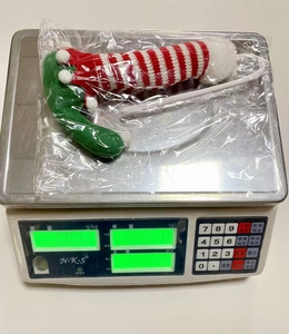 Macro view showing the 32g weight of red-white striped Christmas elf leg decorations