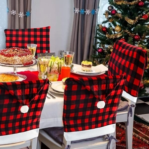 Red and black buffalo plaid Christmas chair covers with pom-poms for festive dining decor